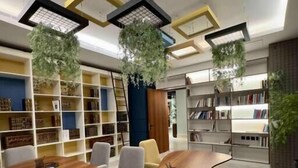 Una sala de reuniones moderna con una mesa ovalada de madera, sillas cómodas y estanterías empotradas.