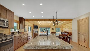 Una cocina amplia con encimeras de granito, armarios de madera y una isla grande.