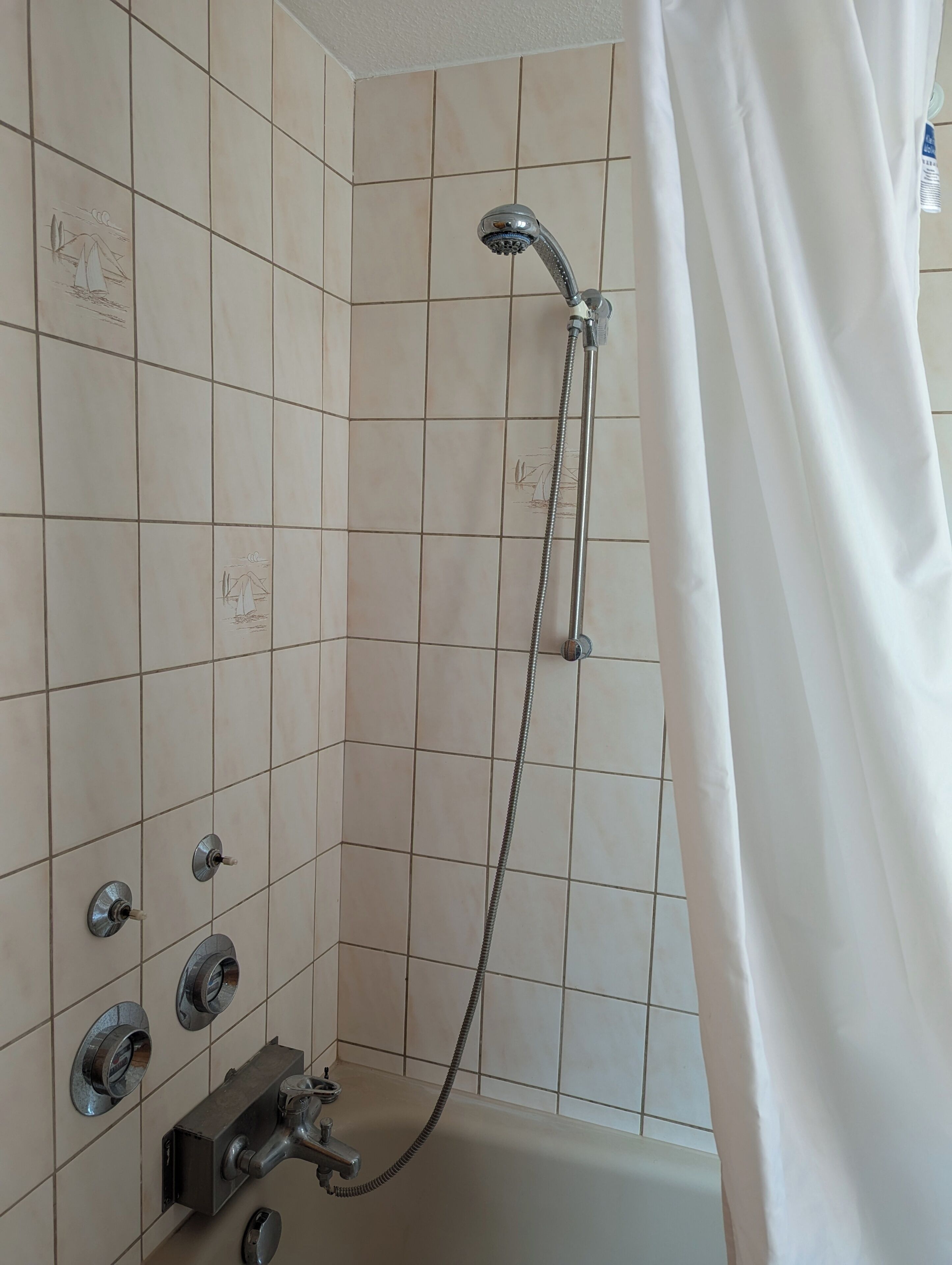 Ein Badezimmer mit Dusche, geflieste Wände und einer Duschvorhang.
