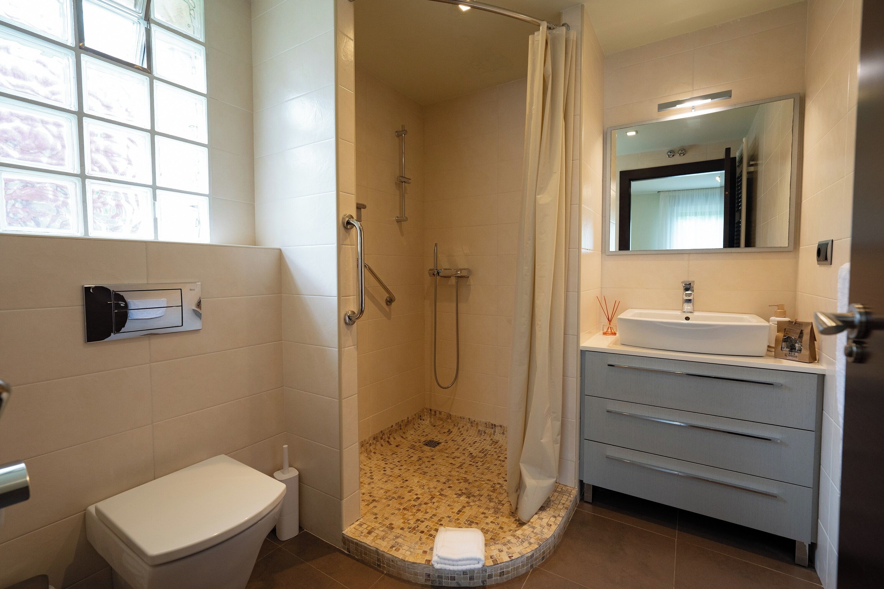 A bathroom with a shower, toilet, and sink.