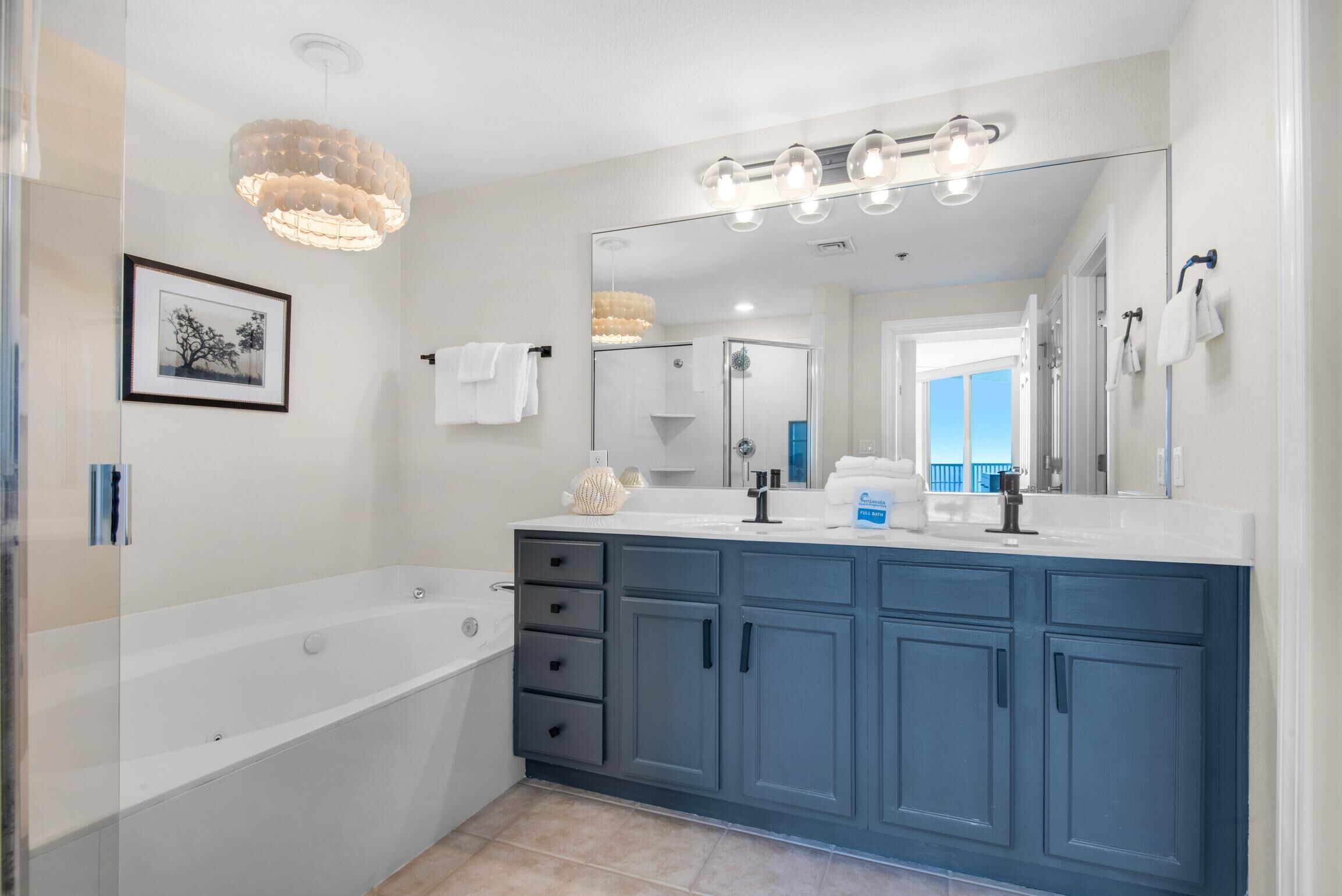 Une salle de bain moderne dotée d’une grande baignoire, d’un meuble-lavabo avec miroir et d’un espace douche.