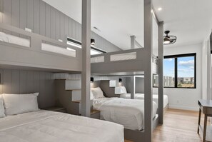 Cozy retreat with bunk beds, shelving, and a large window offering a view of the outside.