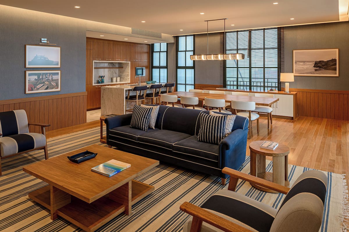 Een moderne hotellobby met een bank, stoelen, een eetgedeelte en kunstwerken aan de wanden.