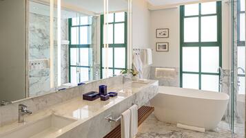 A modern bathroom with a freestanding bathtub, a large vanity with a marble countertop, and a large mirror.