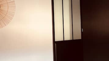 A room with a sliding door, a hanging light fixture, and a wall-mounted decorative piece.