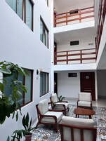 Un edificio de varios niveles con un patio que ofrece mesas al aire libre y plantas en macetas.
