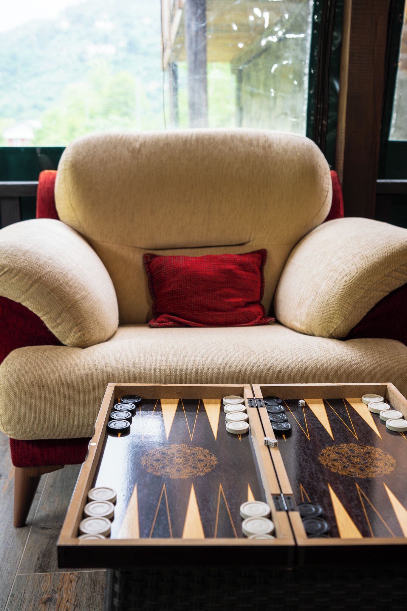 A mahjong table with tiles and a red cushion on a chair.
