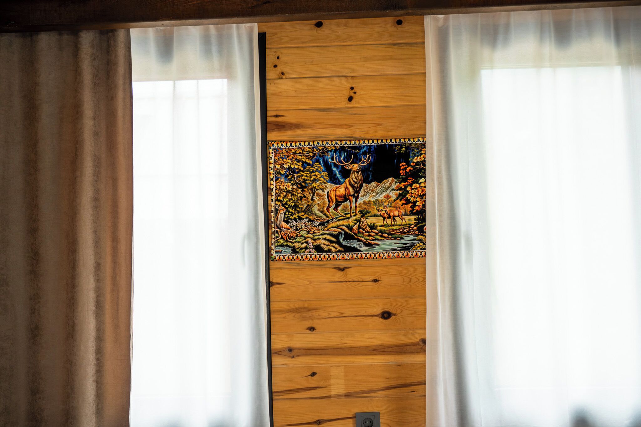 A wooden door with a stained glass window depicting a deer and foliage.
