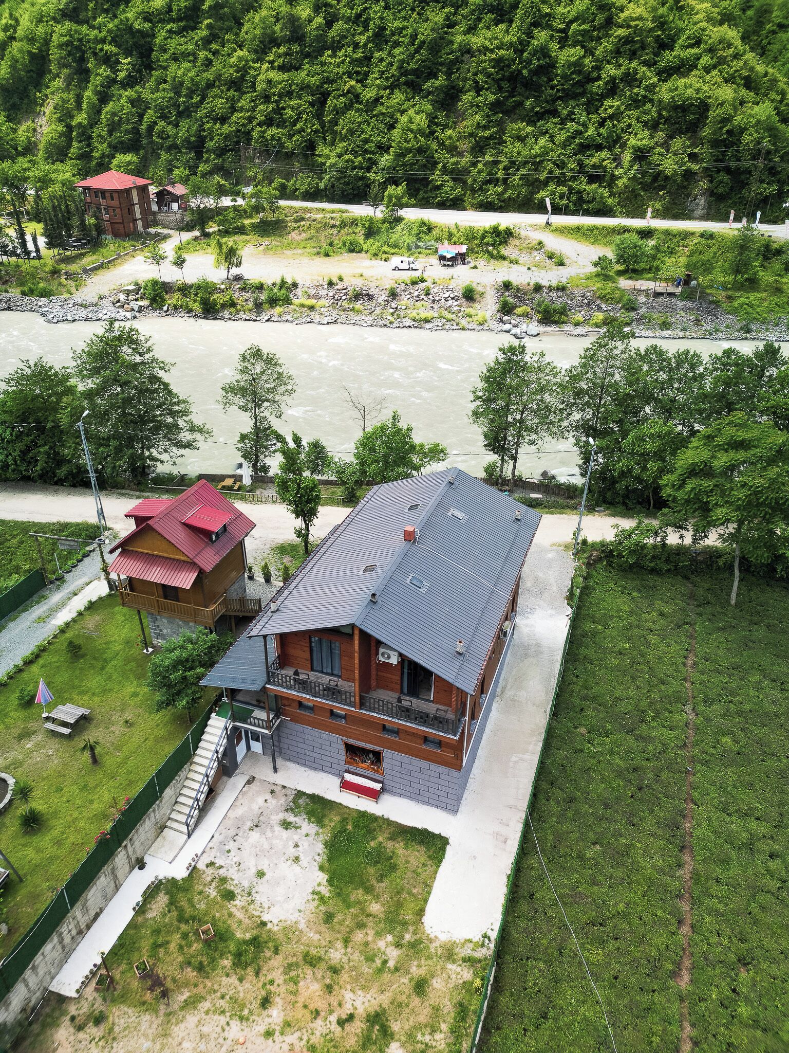 A lodge with a balcony, a covered patio, and a view of a river.