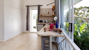 Una cocina moderna con encimera de madera, microondas, tostadora y una planta colgante.