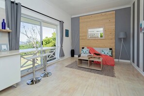 Departamento superior, vista al océano | Área de sala de estar | Smart TV de 43 pulgadas con canales digitales y libros 