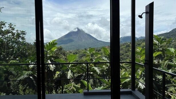 Un balcone con vista su una montagna e vegetazione lussureggiante.
