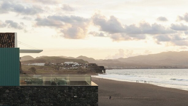 A coastal building with a stone facade, a balcony with chairs, and a view of the beach and distant hills. - Moinho da Areia (Ribeira Grande)