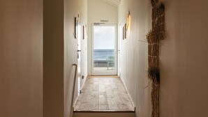 A hallway leading to a door labeled "TERRAÇO" with a view of the sea. - Moinho da Areia (Ribeira Grande)