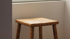 A wicker stool in front of a window with a view of the ocean. - Moinho da Areia (Ribeira Grande)