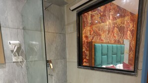 A modern bathroom with a glass-enclosed shower, a white bathtub, and a vanity with a mirror. - Hotel M2M  Narela (New Delhi)