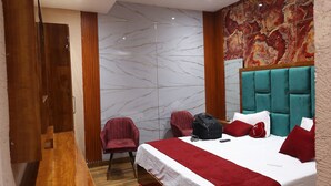A modern hotel room with a large bed, a wooden bench, a red carpet, and a marble wall. - Hotel M2M  Narela (New Delhi)