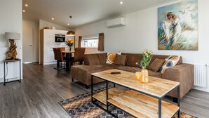 A modern living room with a sectional sofa, a wooden coffee table, and a painting on the wall.