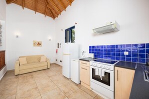 A compact kitchen with a built-in oven, a refrigerator, and a stove.