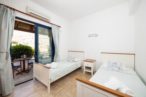 Ein Schlafzimmer mit zwei Einzelbetten, einem kleinen Tisch und einem Stuhl.