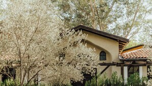 A pathway leading to a building with a tiled roof and a beige facade. - Eski Yeni Tatil Evi (Kumluca)