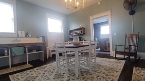 Una cocina con comedor, un ventanal grande y un ventilador.