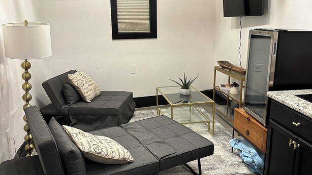 Un espacio habitable compacto con sofá, televisor, una mesita y un armario.