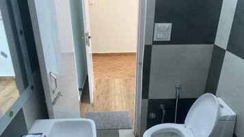 A bathroom with a white sink, a toilet, and a shower.