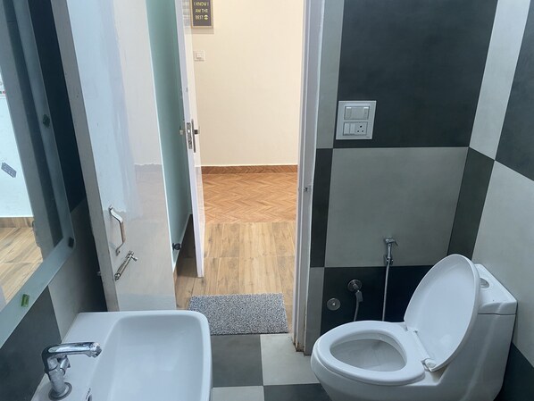 A bathroom with a white sink, a toilet, and a shower. - Hotel Nirmal - Budget Friendly Rooms near Fortis Hospital and Marriage Palaces (Amritsar)