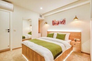 A bedroom with a bed, bedside table, and a mirror. - Elephant In The Room (Istanbul)