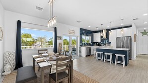 A modern kitchen with a central island, bar stools, and a view to the outside. - Blue Pearl Waterfront Oasis w Pool 70 Dock (Marathon)