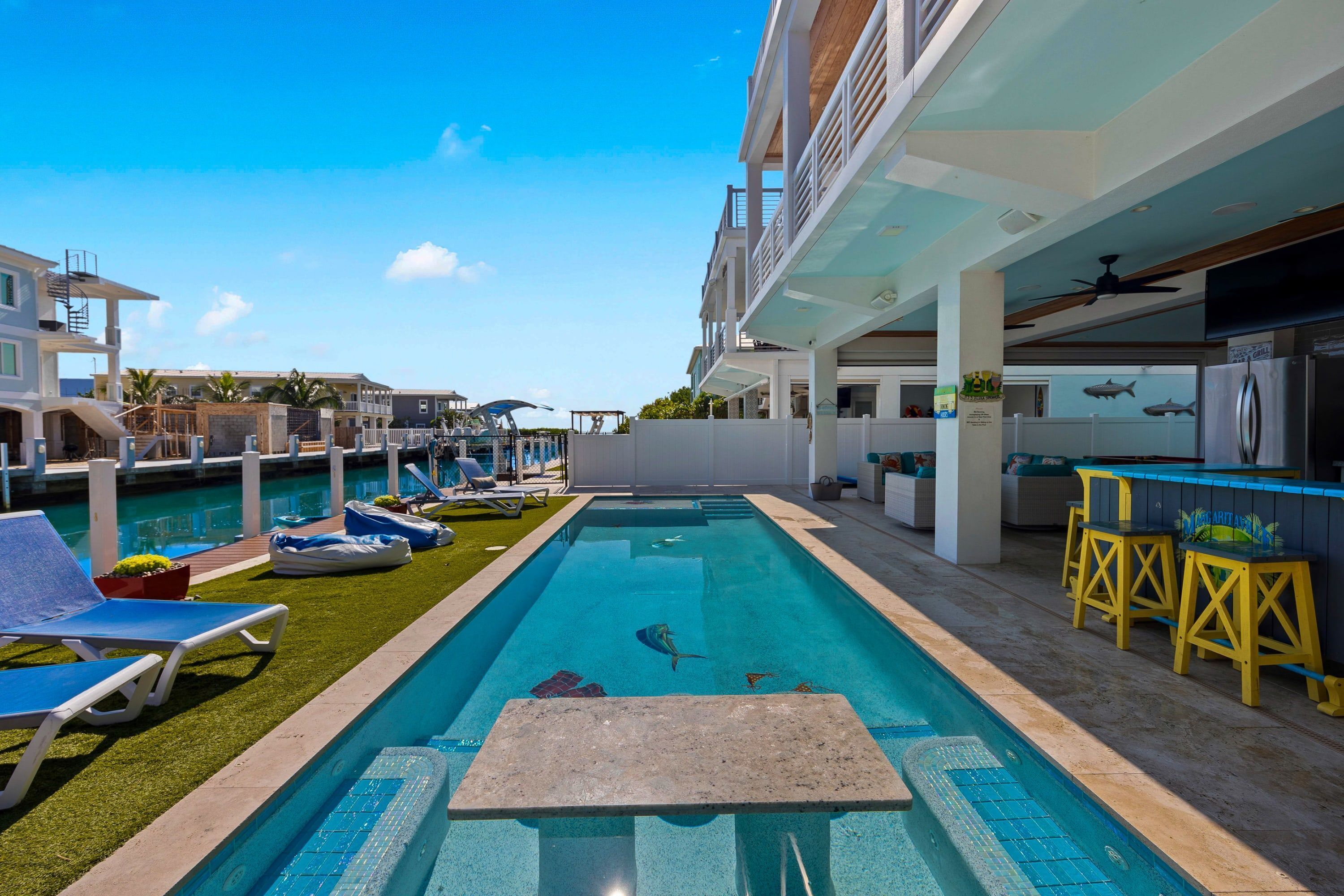 A swimming pool with lounge chairs and a bar area.