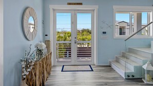 A modern interior with a glass staircase, a wooden railing, and a view through a glass door. - Luxury Waterfront Oasis w Heated Pool and 50 Dock (Marathon)