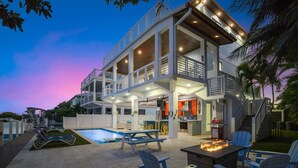 A multi-level house with a pool, outdoor seating, and a barbecue area. - Luxury Waterfront Oasis w Heated Pool and 50 Dock (Marathon)