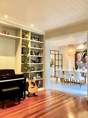 Relax and dine in this cozy space with a piano, guitar, and dining area.