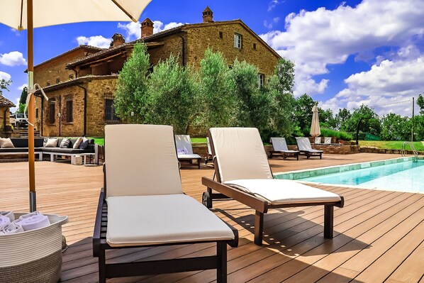 A wooden deck with lounge chairs and a pool. - Podere Cavalbianco (Monte San Savino)