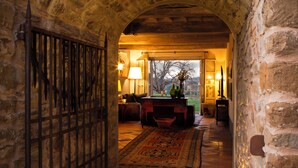 An arched stone corridor leading to a room with a billiards table, a lamp, and a view of the outdoors. - Podere Cavalbianco (Monte San Savino)