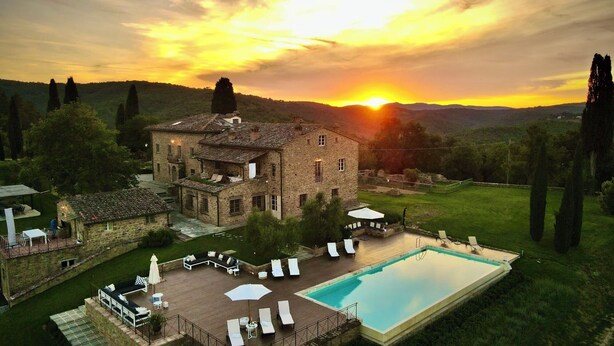 A stone villa with a swimming pool, outdoor seating, and a scenic sunset view. - Podere Cavalbianco (Monte San Savino)