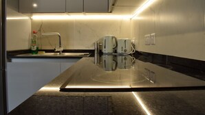 Una cucina moderna con un piano di lavoro in acciaio inossidabile, un lavello integrato e una macchina per il caffè.