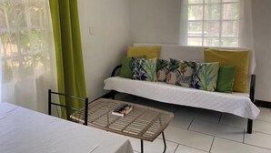 A room with a bed, a table, and a window with curtains. - Rupia Apartment.

 (San Pedro Town)