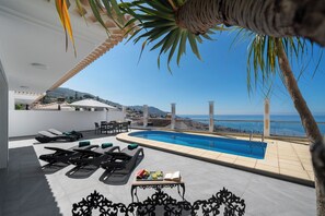 A rooftop pool area with sun loungers and a table with fruits and a book. - Amazing sea views over Funchal | Atlantic Sunset (Funchal)