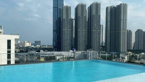 Una piscina sul tetto con vista libera su alti grattacieli sullo sfondo.
