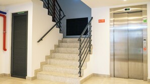 A modern interior with a staircase, a closed door, and an elevator. - N&N Home Porto, your home in the center of Porto.  (Porto)