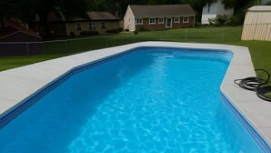 Une piscine rectangulaire à l’eau d’un bleu limpide, dont le bord est revêtu de carreaux.
