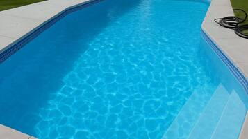 A rectangular swimming pool with clear blue water and a tiled edge.