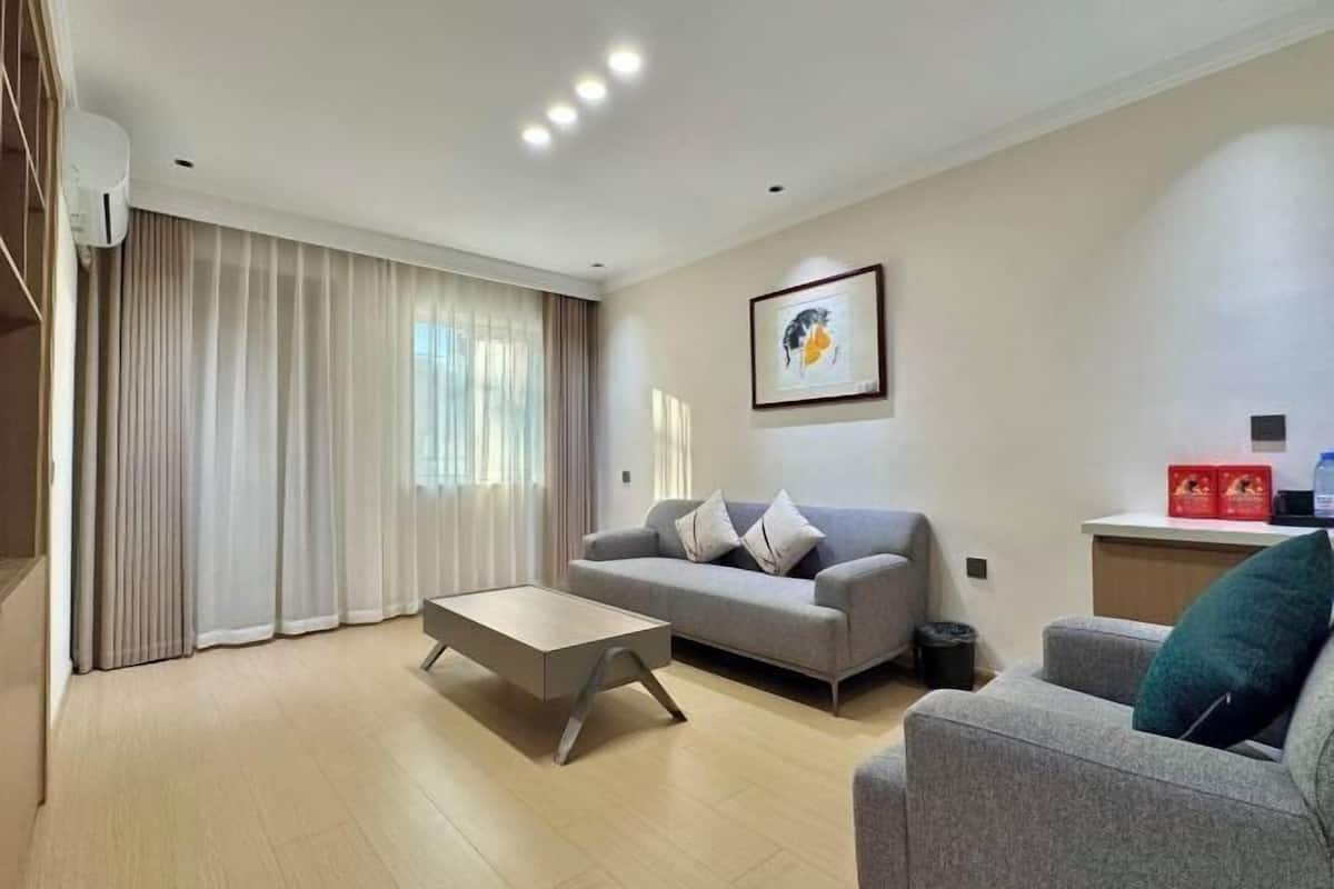 A modern living room with a grey sofa, a coffee table, and a framed picture on the wall.