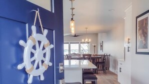 Une cuisine moderne dotée d’un îlot central, d’un plancher en bois et d’un coin repas avec des chaises et une table.