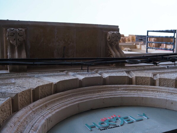 A stone structure with a circular viewing platform and a metal railing. - Homely Catania (Catania)