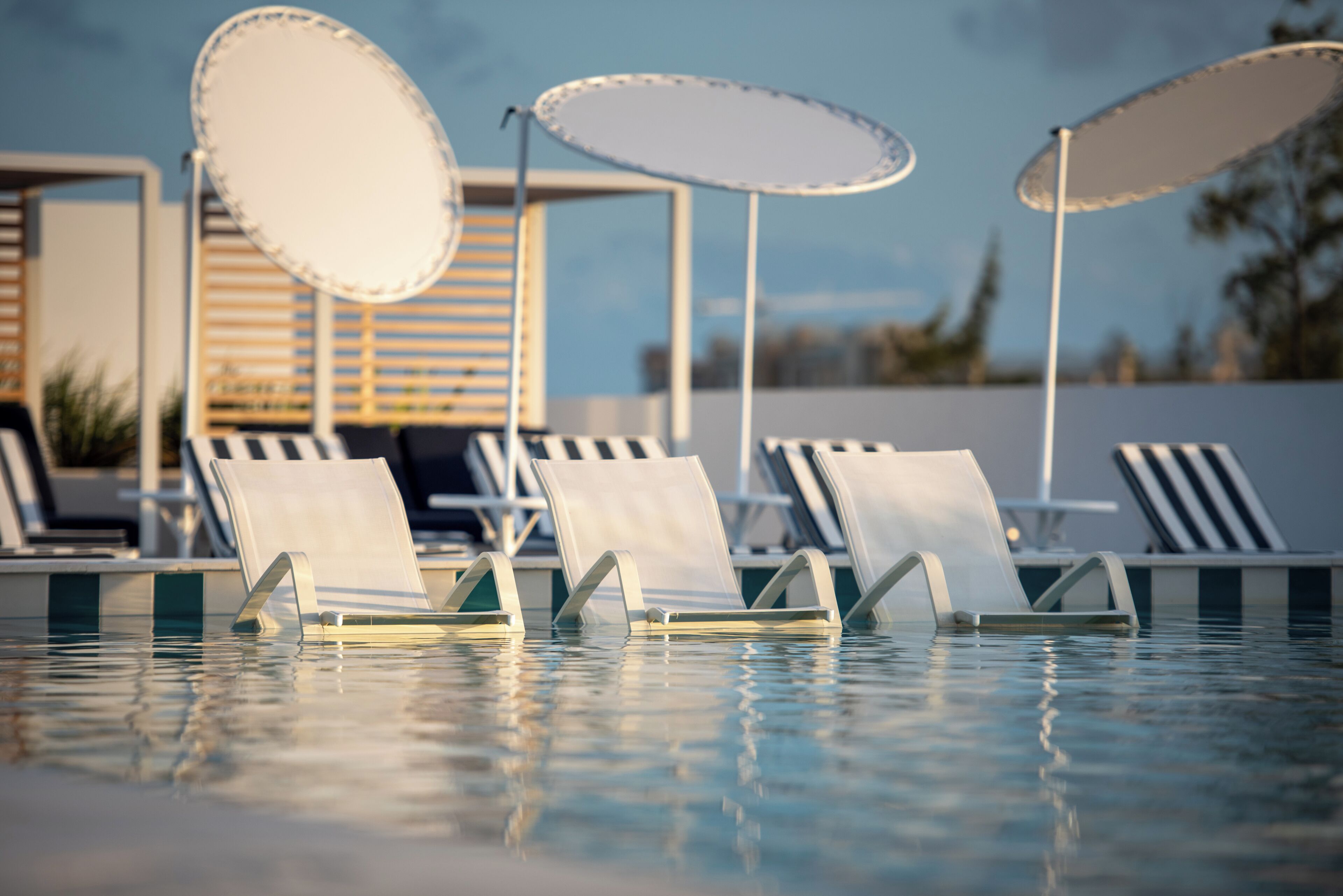 A poolside area with lounge chairs and umbrellas.