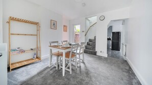 Un espace repas comprenant une table, des chaises et une étagère en bois.